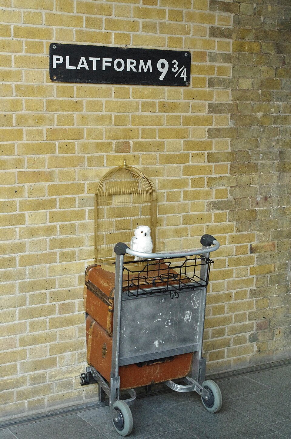 The Platform 9¾ sign at King’s Cross station with a luggage trolley disappearing into the wall